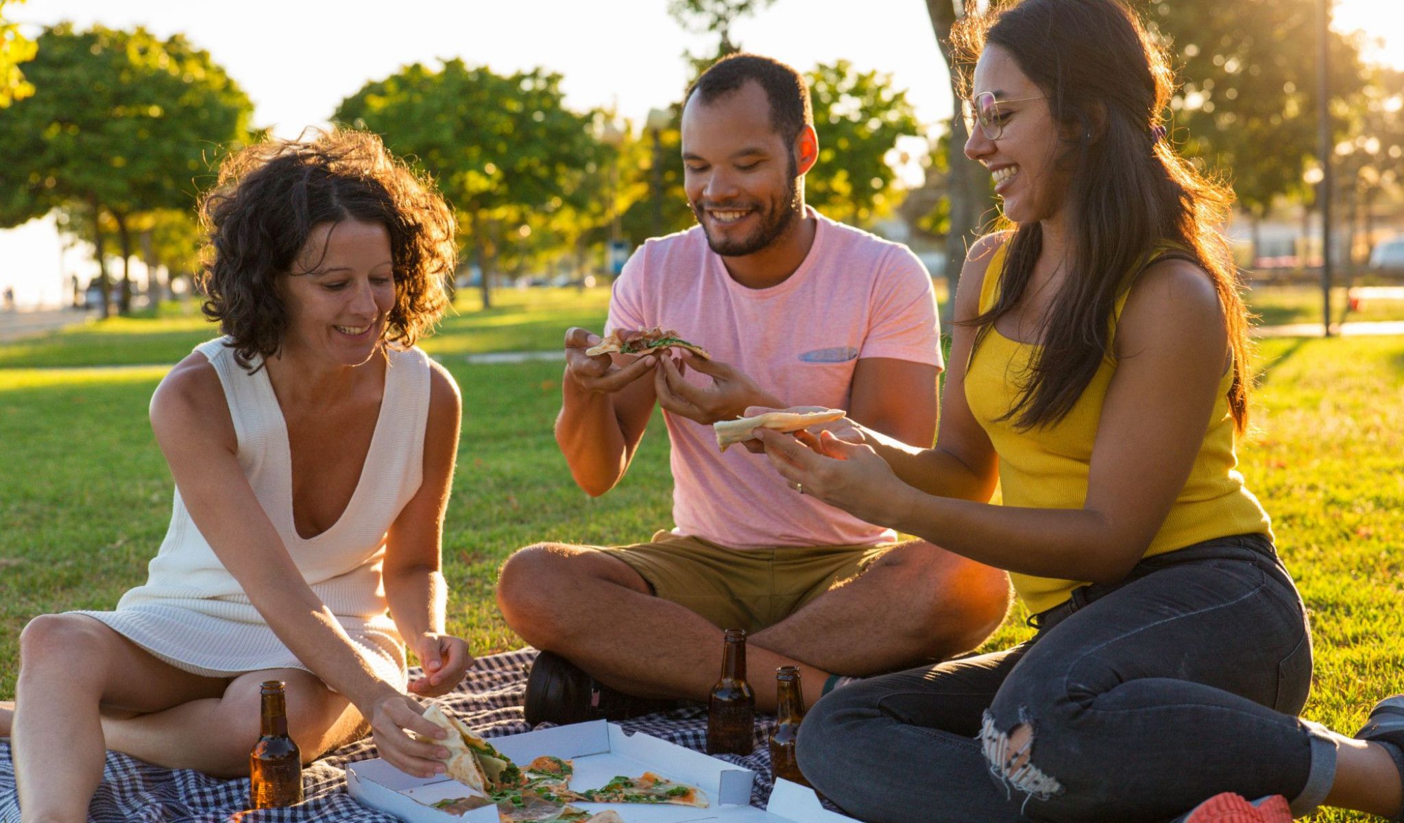 Cosgrove Hill at Chapel Hiil, NC. Three friends enjoying pizza on the grass in a park.