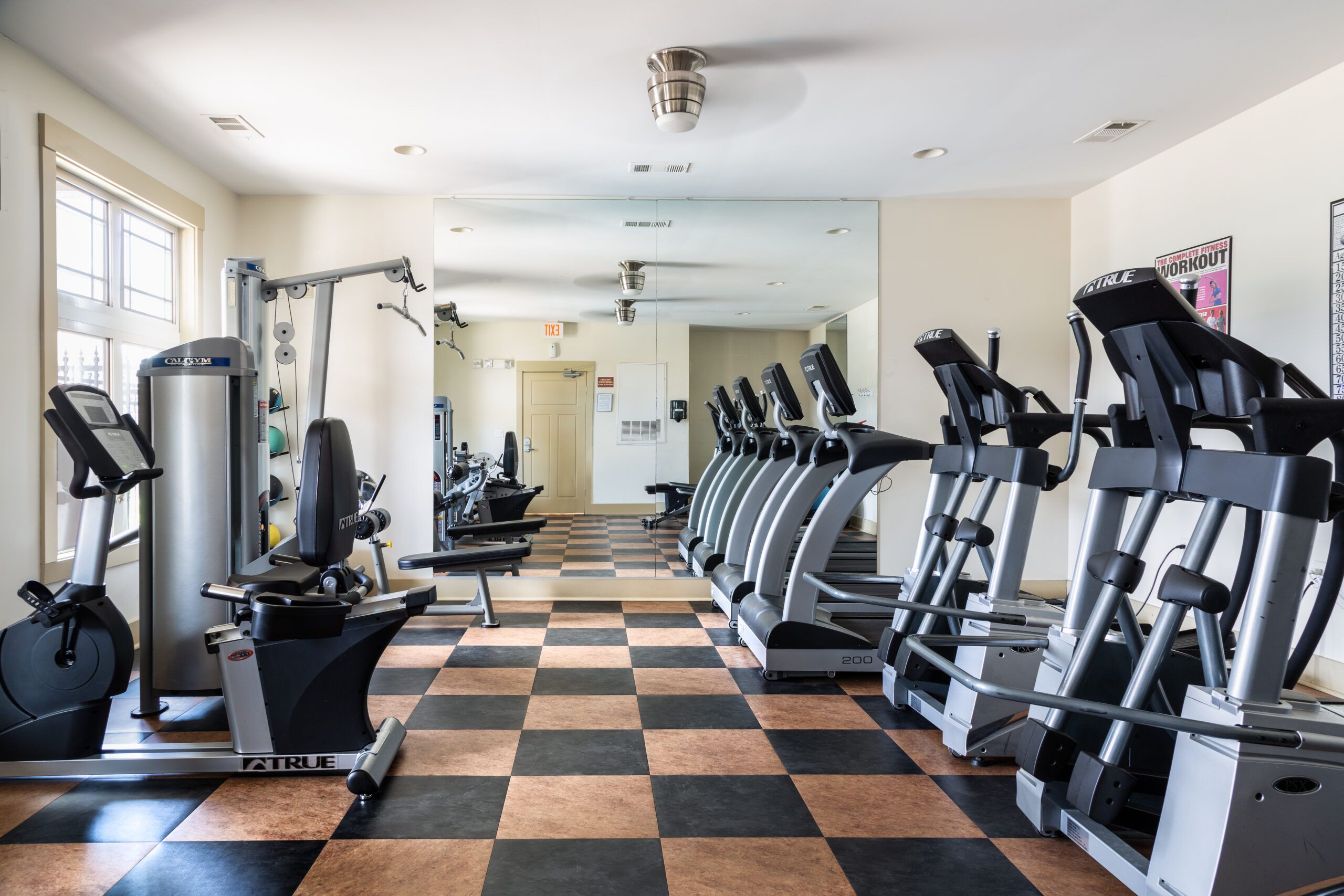 Cosgrove Hill at Chapel Hiil, NC Fitness center with treadmills, weights, and mirrors for workouts.