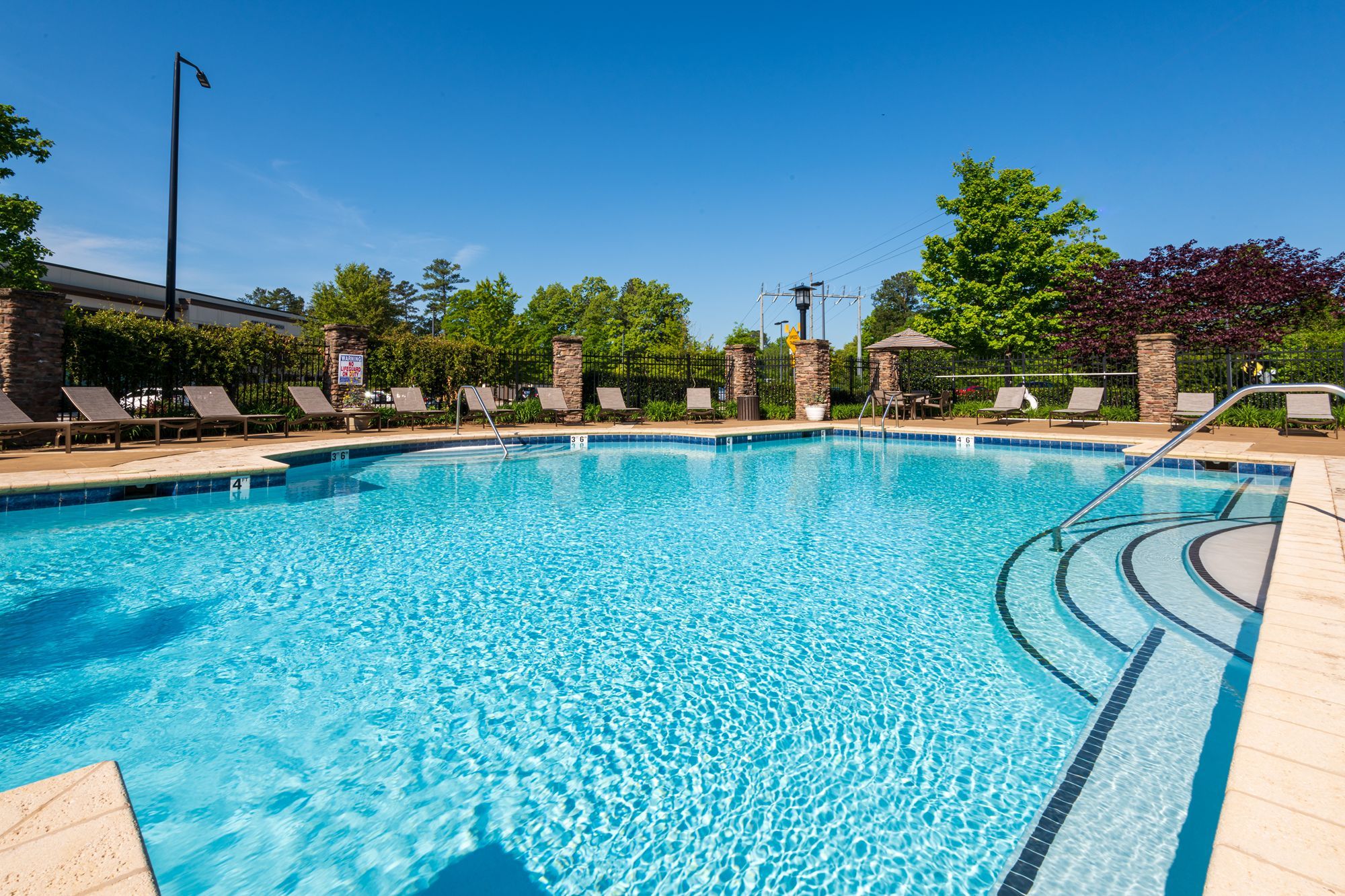 Cosgrove Hill at Chapel Hiil, NC. Resort pool nestled in park setting, with trees and umbrellas in background.