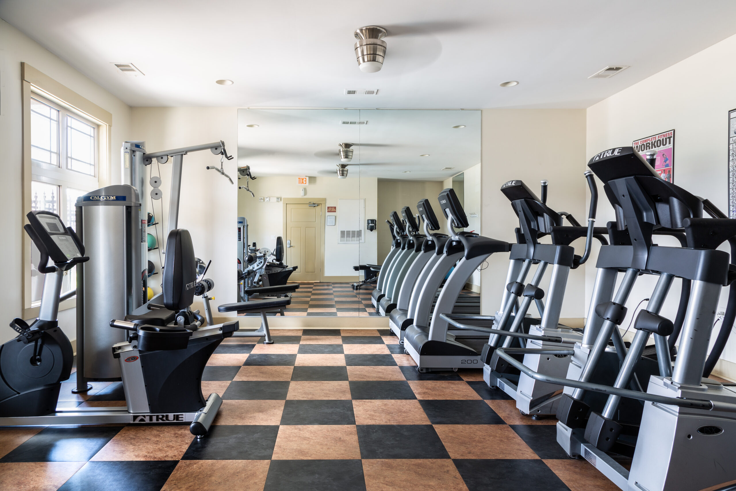 Cosgrove Hill at Chapel Hiil, NC Fitness center with treadmills, weights, and mirrors for workouts.